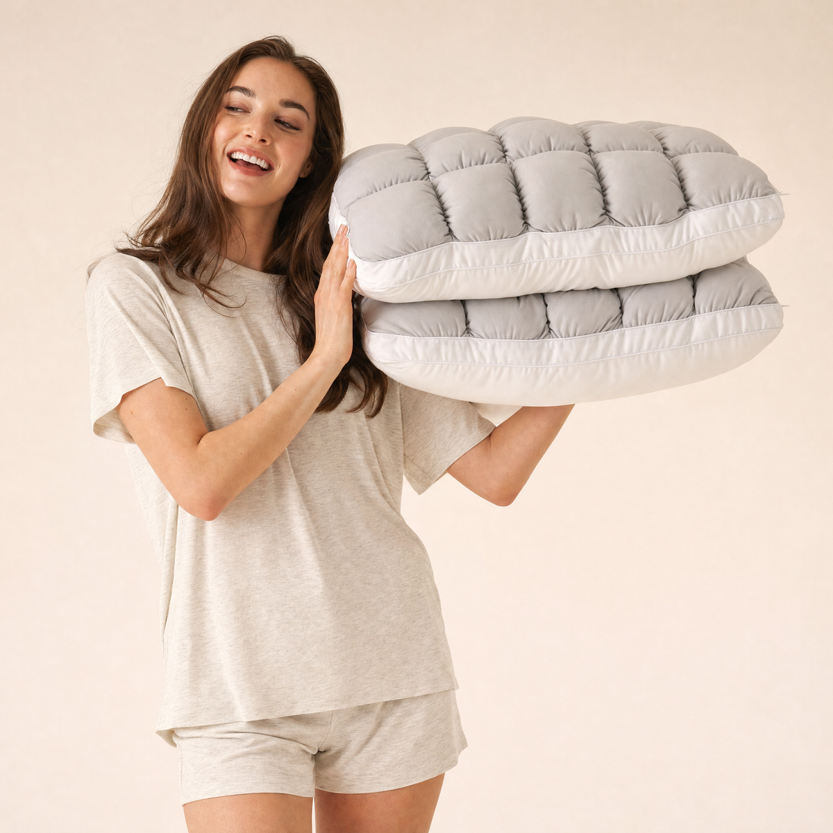 Woman holding two Gray Lune pillows
