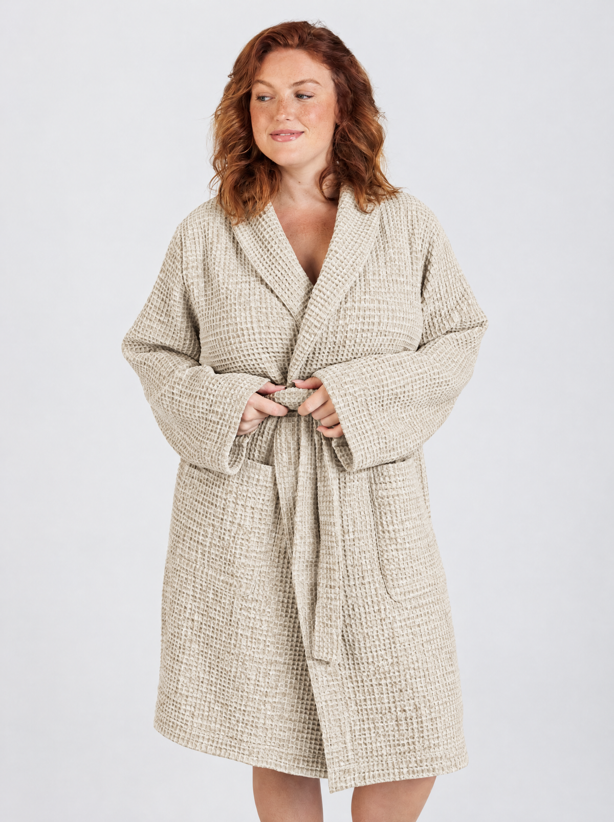 Tying the belt of the Truenova Waffle Robe in Tan