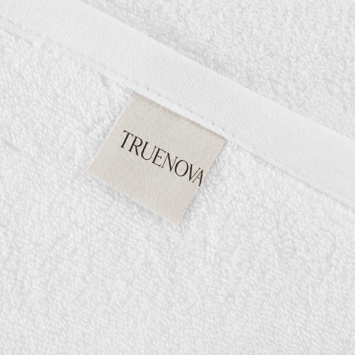 Close-up of a Truenova label on a white cotton towel